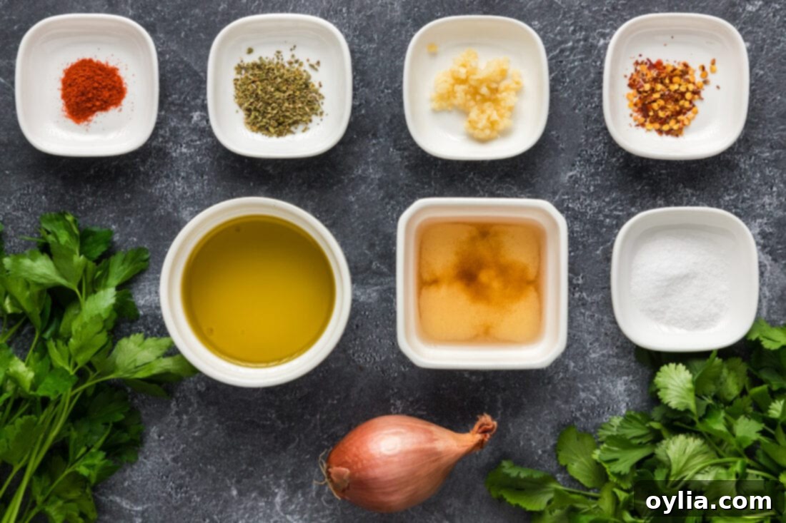 A selection of fresh ingredients including parsley, cilantro, garlic, shallots, olive oil, and vinegar, laid out for chimichurri