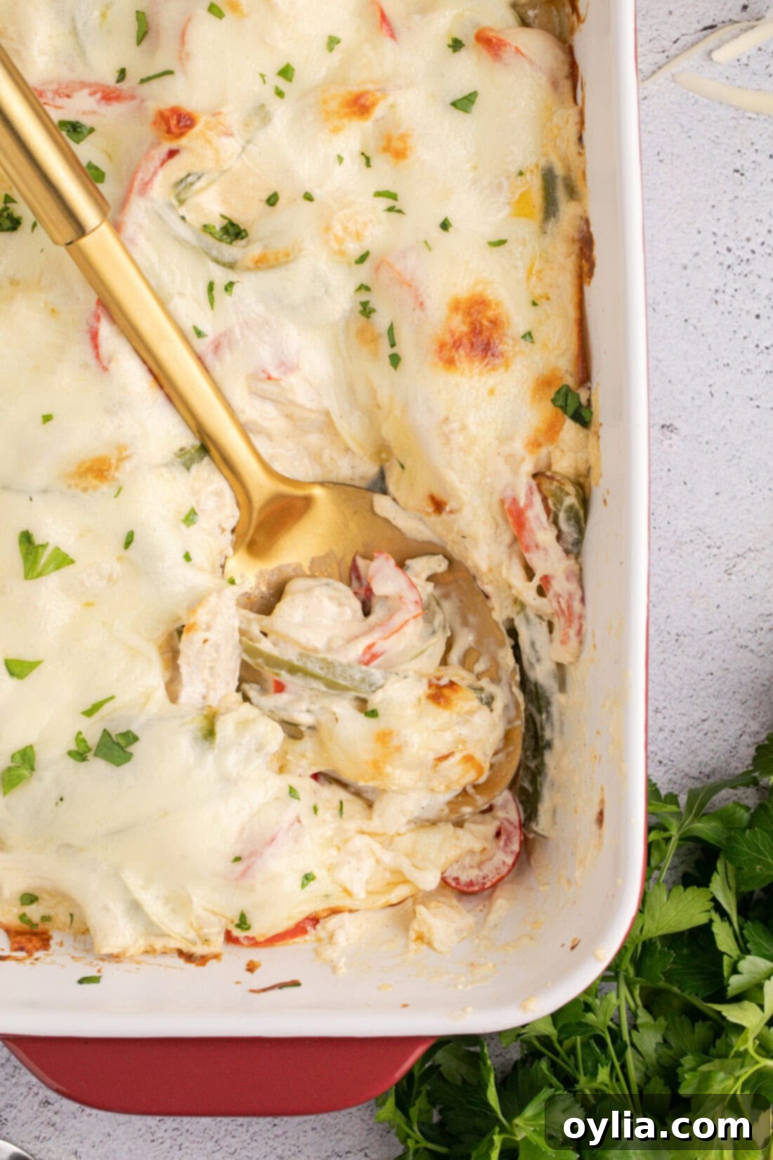 Spoon in a Philly Chicken Cheesesteak Casserole, showcasing the creamy, cheesy texture
