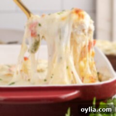 Spoonful of Philly Chicken Cheesesteak Casserole being lifted up from the casserole dish, showing rich details