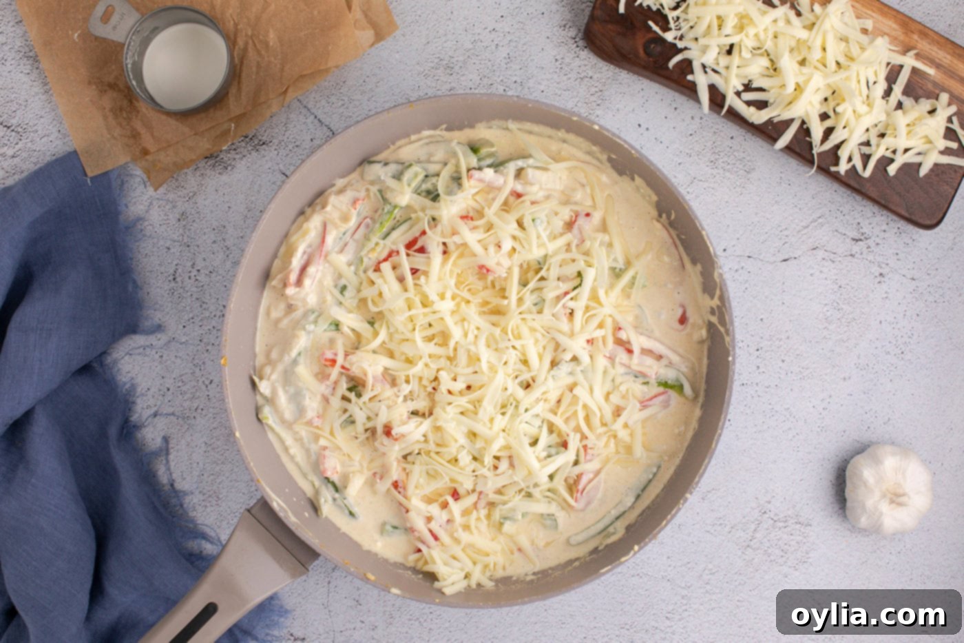 adding pepperjack cheese to skillet with sauteed peppers and onions to create a creamy sauce