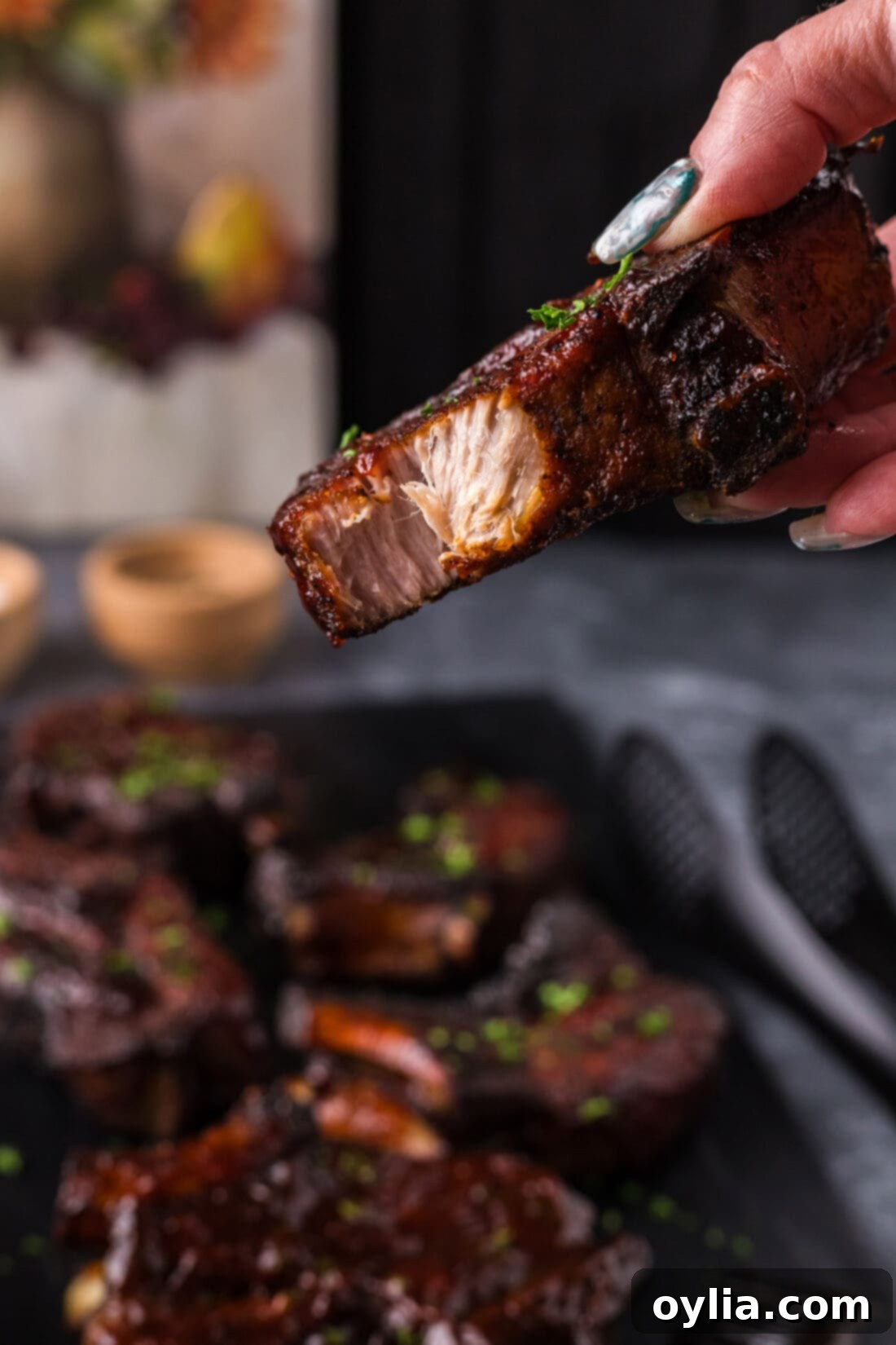 Hand holding up a Country Style Rib with a bite taken out