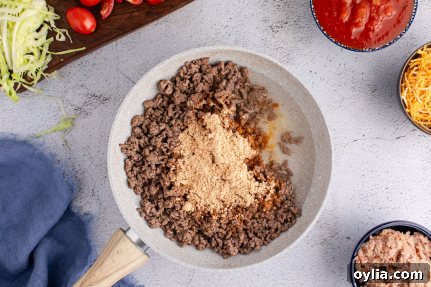 taco seasoning added to skillet with ground beef