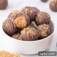 A bowl of Nutter Butter Balls, with one ball having a bite taken out of it, showing its delicious peanut butter filling.
