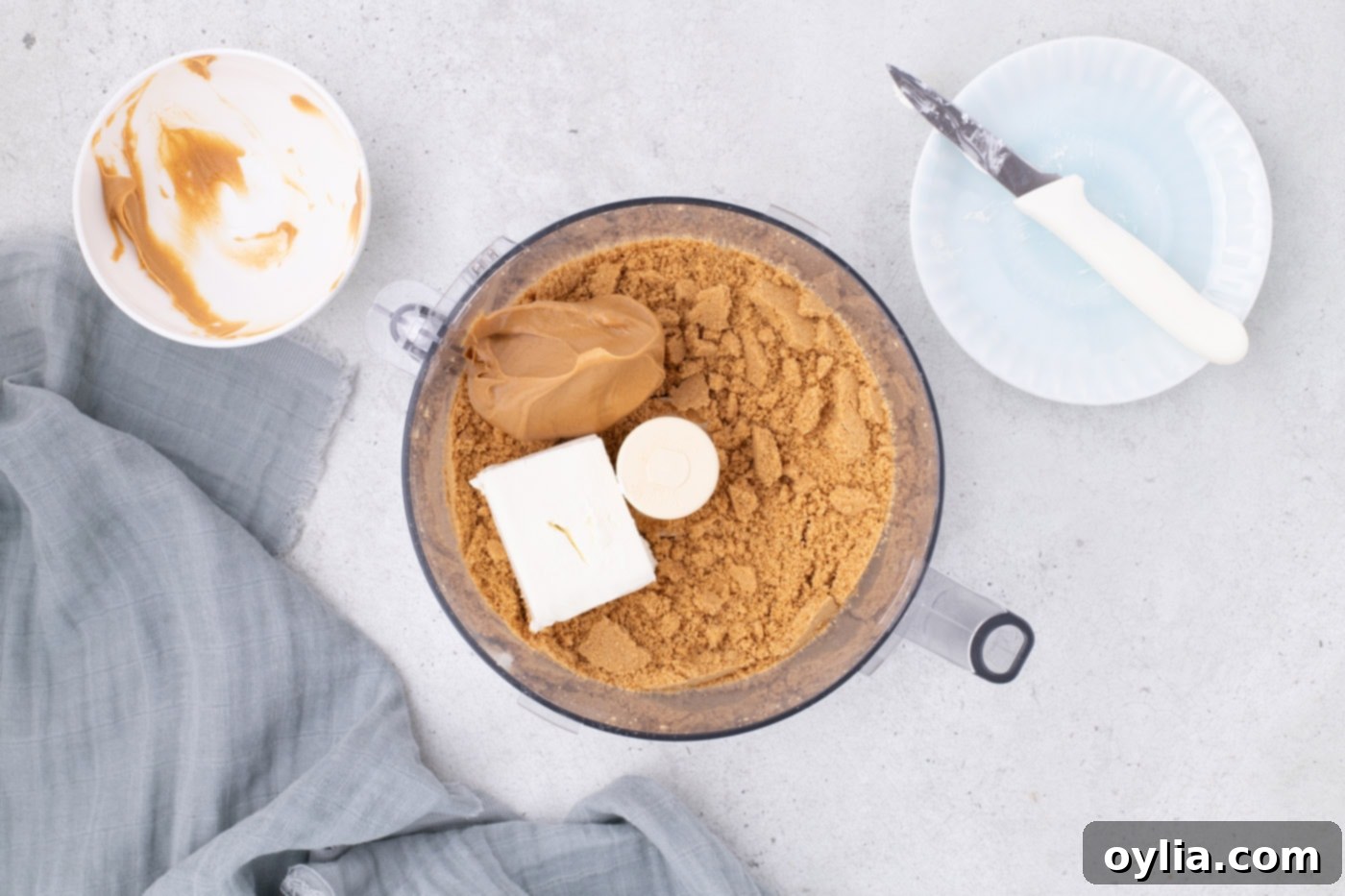 Cream cheese and creamy peanut butter added to Nutter Butter cookie crumbles in a food processor, before mixing.