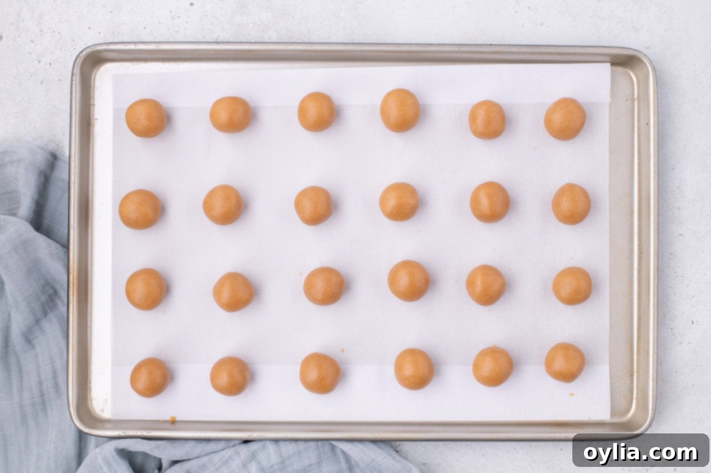 Nutter Butter cookie balls neatly arranged on a baking sheet, ready for freezing.
