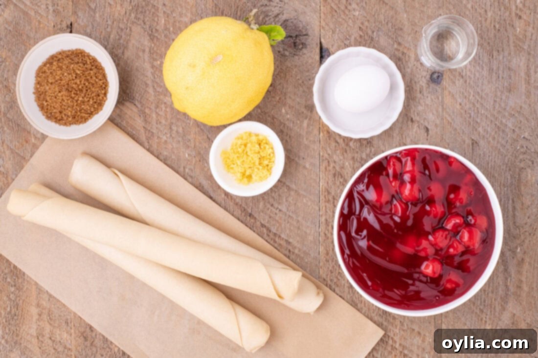 All the necessary ingredients neatly laid out on a wooden surface, including cherry pie filling, pre-made pie crusts, lemon, egg, water, and turbinado sugar for making Cherry Slab Pie.