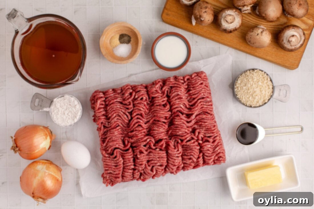 A flat lay of all the fresh and essential ingredients required to make Salisbury Steak Meatballs and gravy, including ground beef, mushrooms, onion, and spices