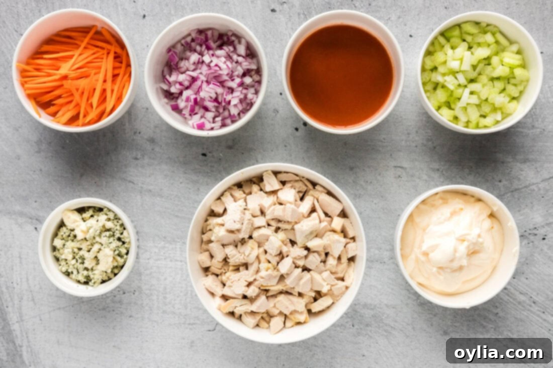 Buffalo Chicken Salad 4 All the fresh ingredients laid out for making Buffalo Chicken Salad: cooked chicken, celery, carrots, red onion, hot sauce, and mayonnaise.