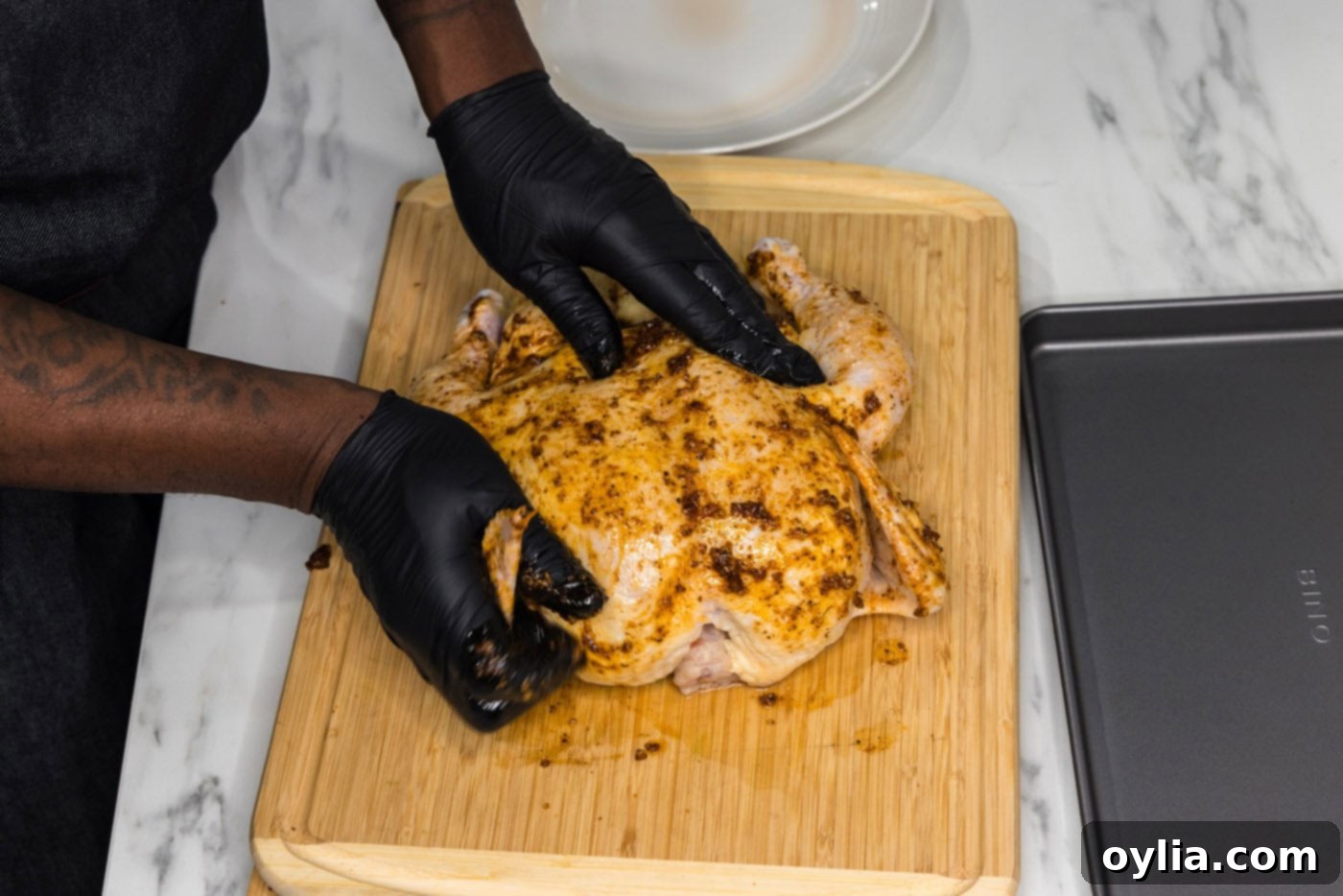 rubbing oil and seasonings over whole chicken