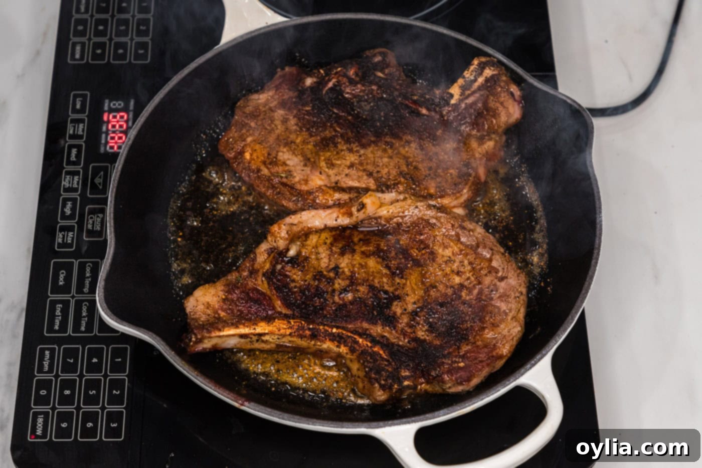 The underside of a seared bone-in ribeye steak displaying a perfectly browned and crispy crust.