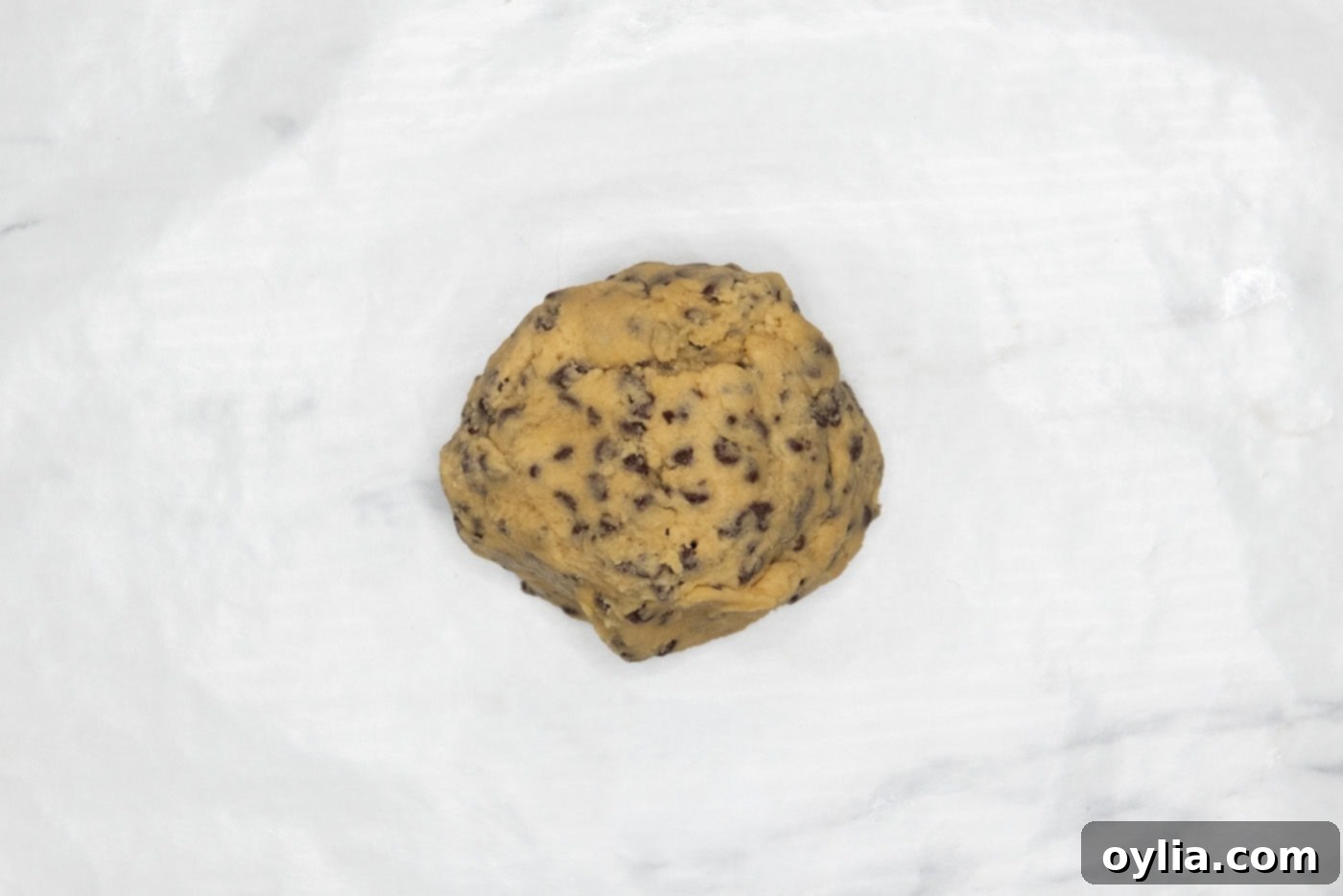 chocolate chip cookie dough ball in parchment paper