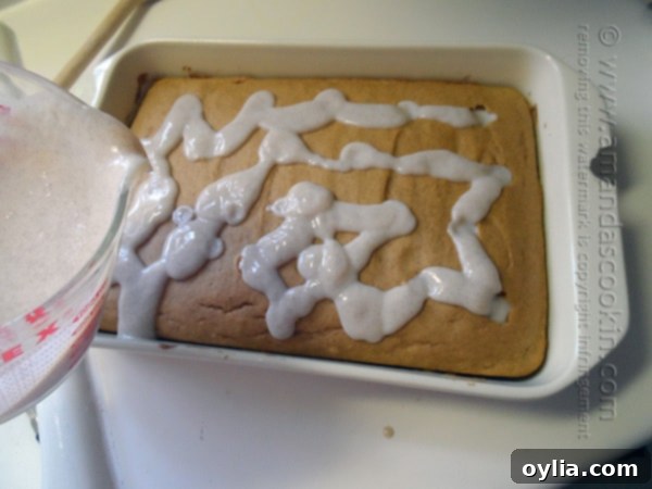 An overhead photo pudding being poured over pumpkin cake in a baking dish.