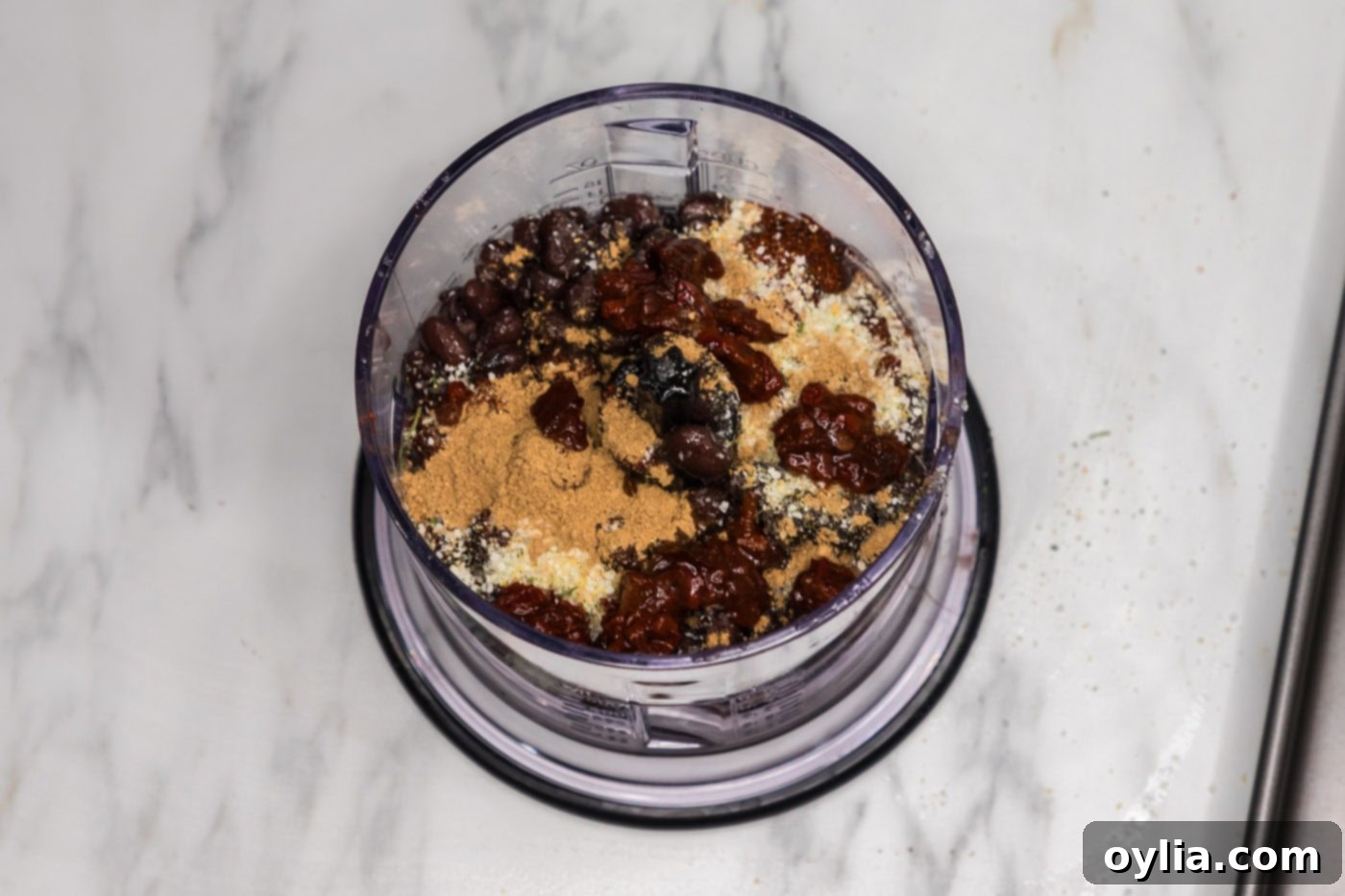 black beans in a food processor with seasonings, chipotle peppers, and soy sauce