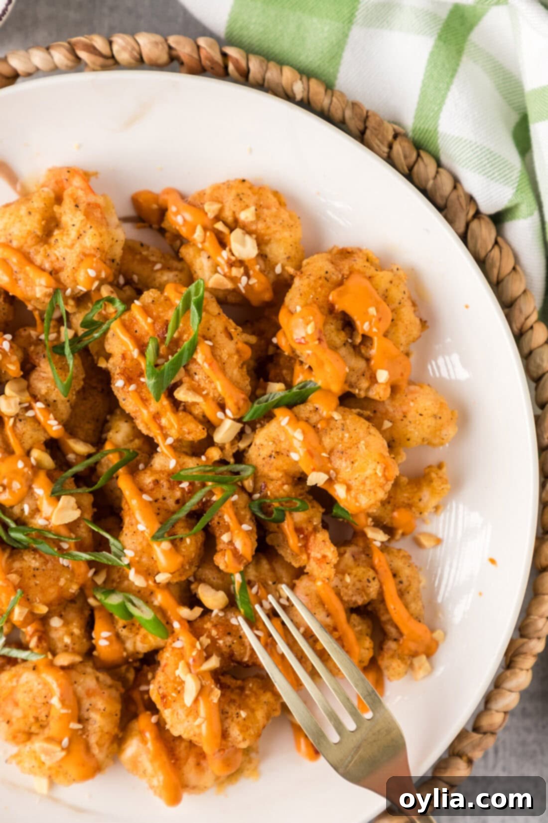 Half a plate of Boom Boom Shrimp with a fork on the side
