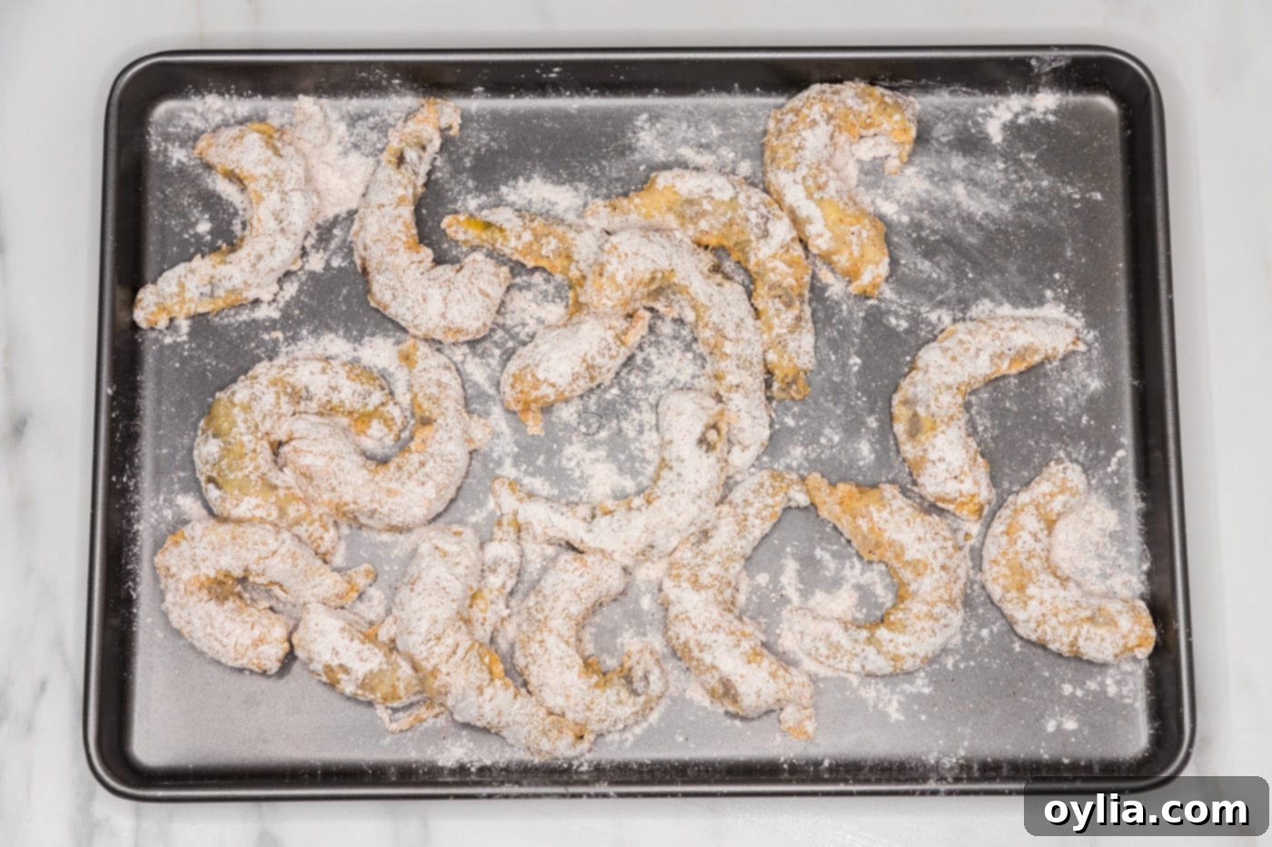 flour dredged shrimp on a baking sheet