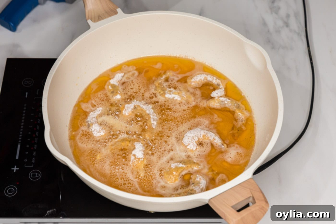 frying shrimp in oil in a skillet