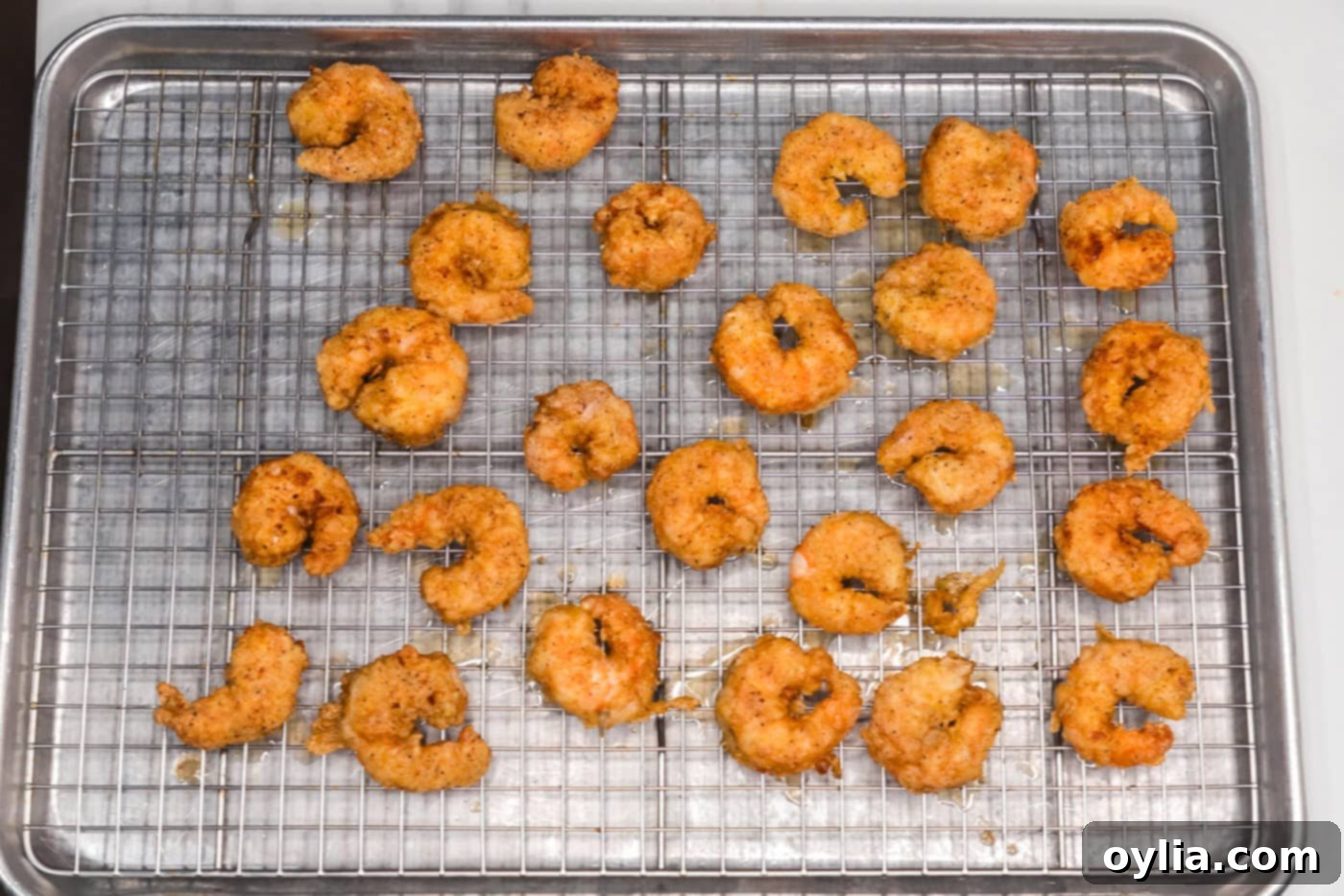 fried shrimp on a wire rack draining