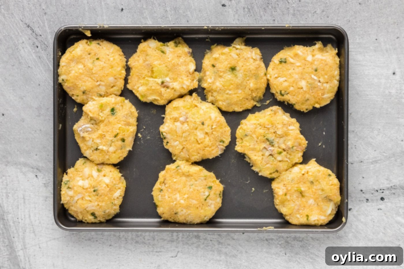 formed cod fish patties on a baking sheet, ready for frying