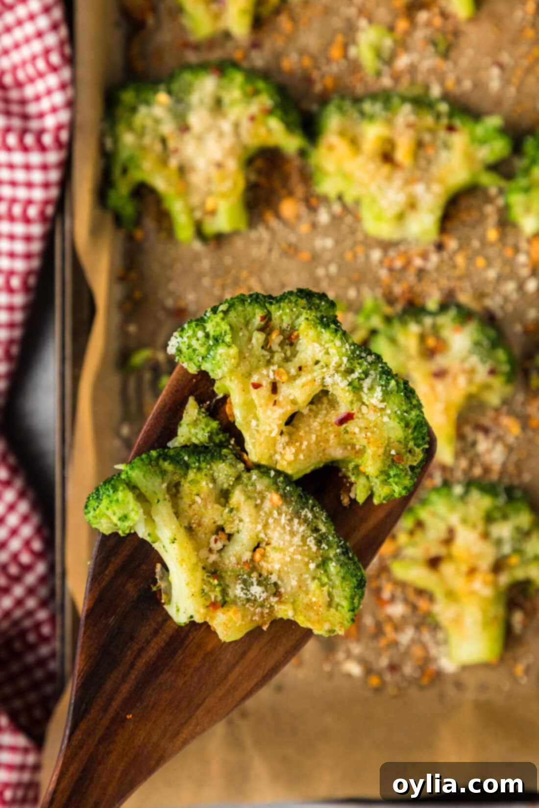Two Smashed Broccoli pieces on a spatula, showcasing their crispy edges and tender interior.