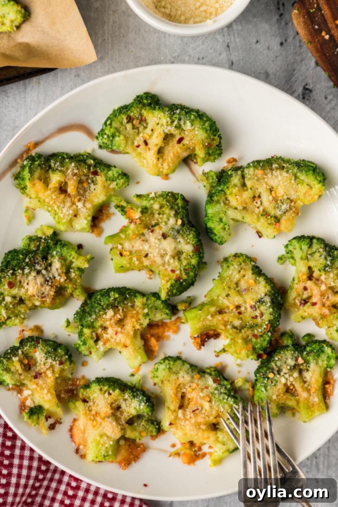 A plate of Smashed Broccoli ready to be served, with forks on the side.