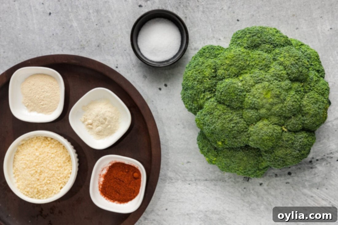 A flat lay image showing all the fresh ingredients needed for Smashed Broccoli: broccoli florets, parmesan cheese, and individual spice containers.