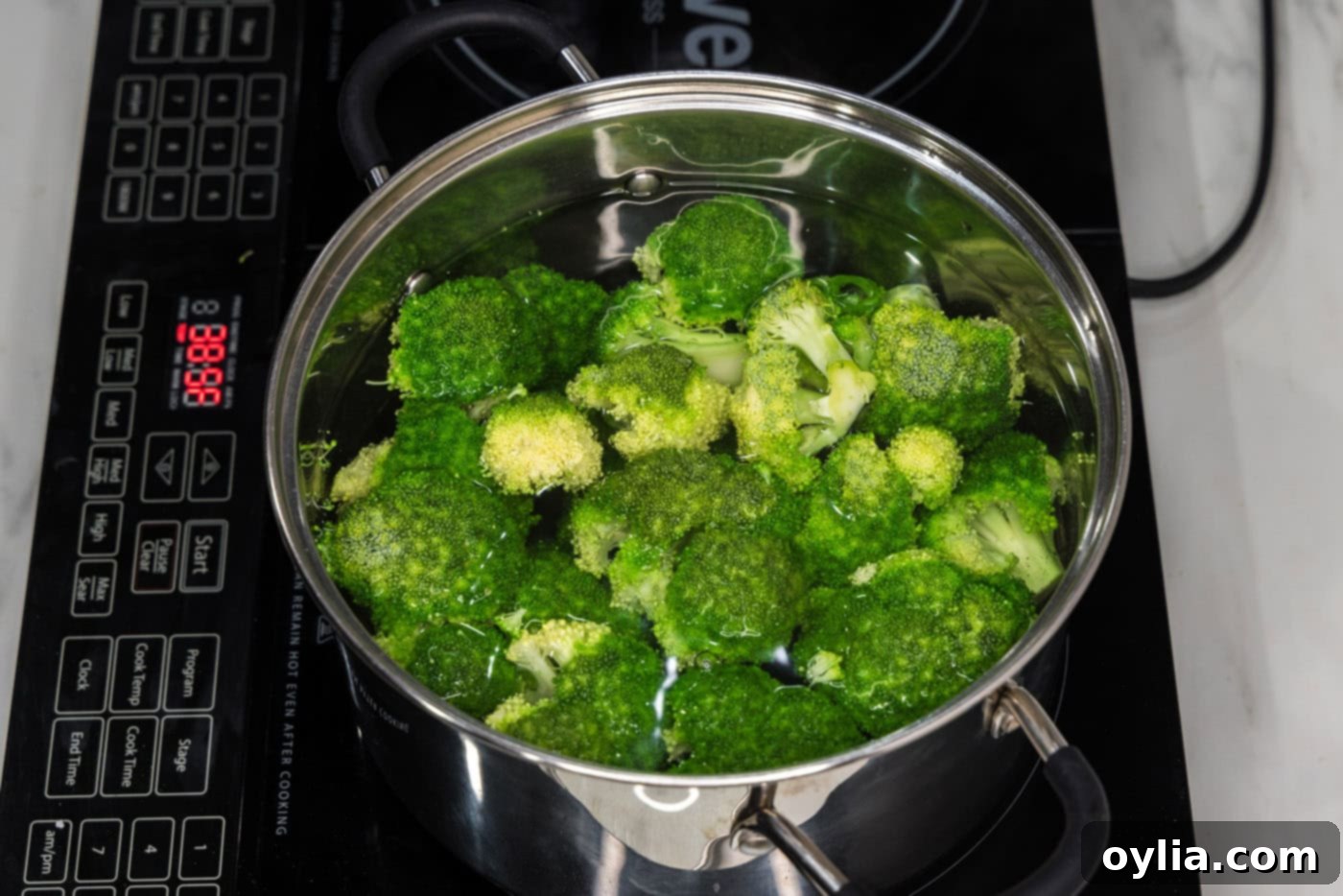 broccoli florets in a pot of water, par-boiling to tenderize before smashing.