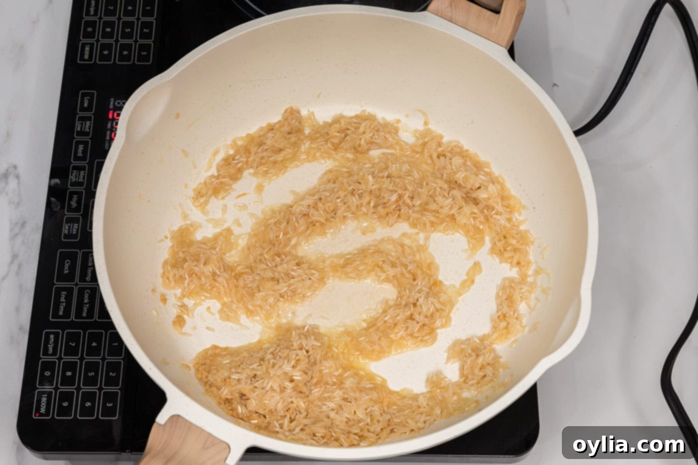 cooking minced garlic with rice in pan with butter, creating an aromatic base