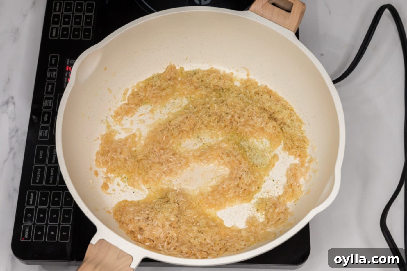 adding garlic salt to garlic butter rice in a skillet for enhanced flavor