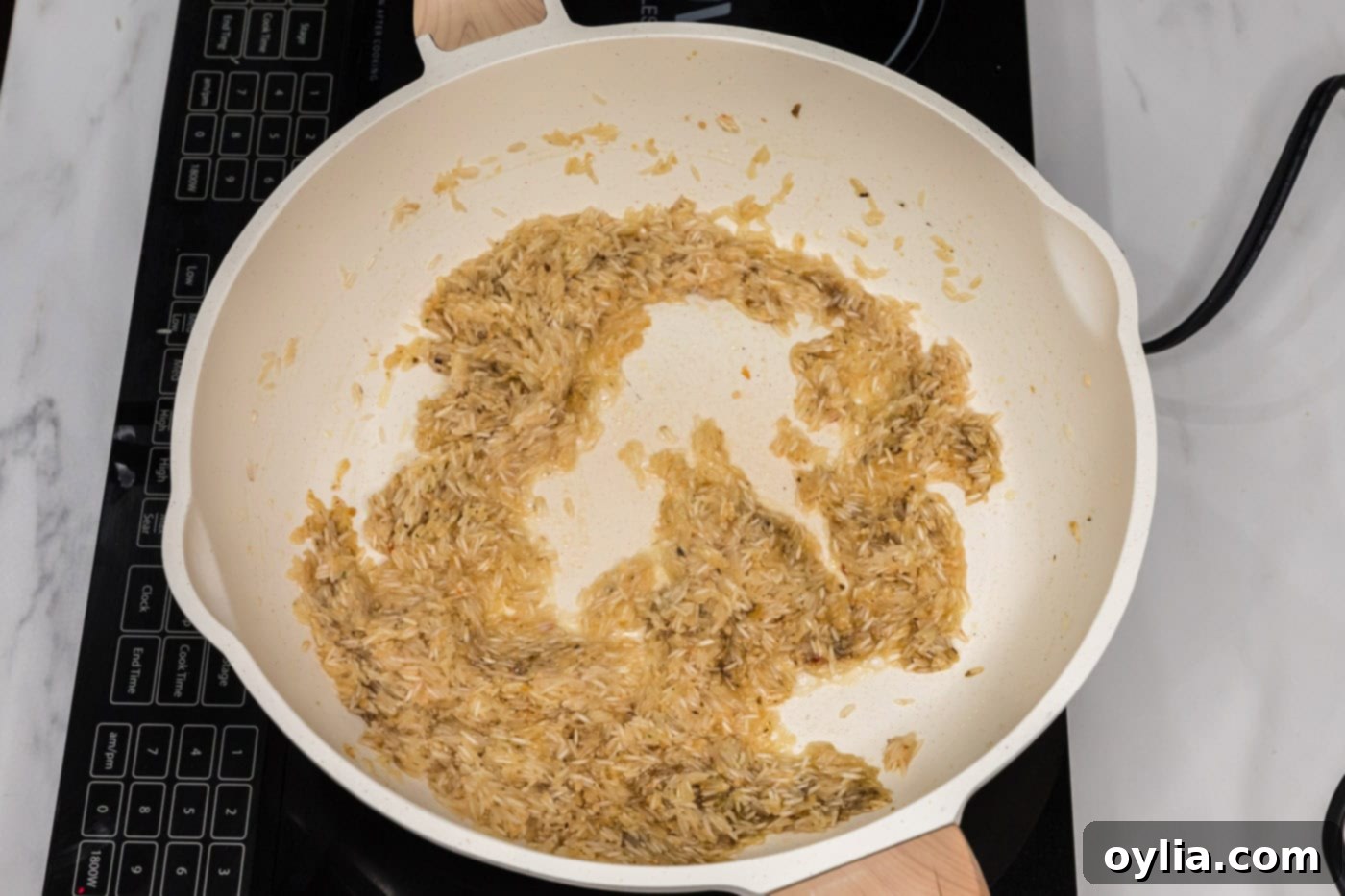 vegetable base added to garlic butter rice in a skillet, mixing to create a rich foundation