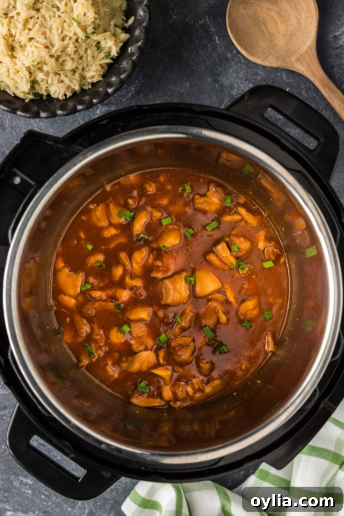 Instant Pot Bourbon Chicken cooking in an Instant Pot, with the sticky sauce bubbling.