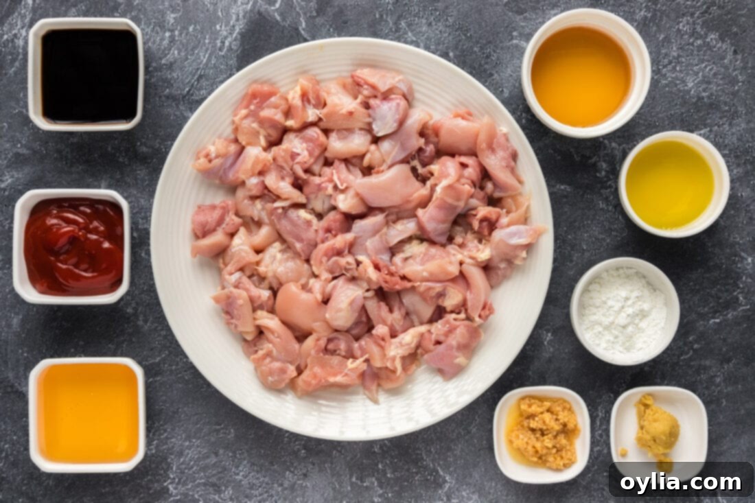 All the fresh ingredients laid out for making Instant Pot Bourbon Chicken, including chicken, sauces, honey, and bourbon.