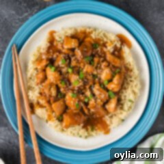 Close up photo of a plate of Instant Pot Bourbon Chicken, showing the glossy, sticky sauce on the chicken.