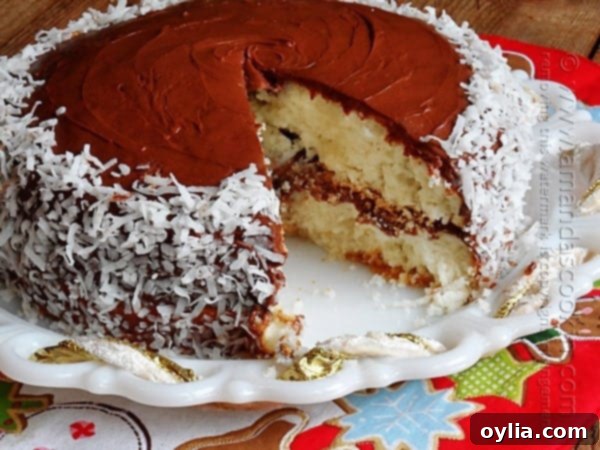 A close-up of the moist layers of the Almond Joy Coconut Snowflake Cake, showing the frosting and coconut flakes.
