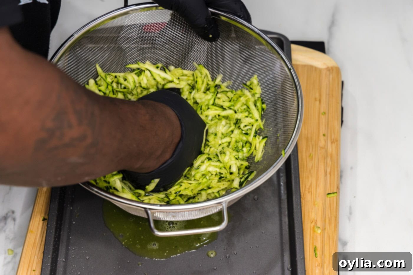 squeezing moisture out of zucchini in a colander