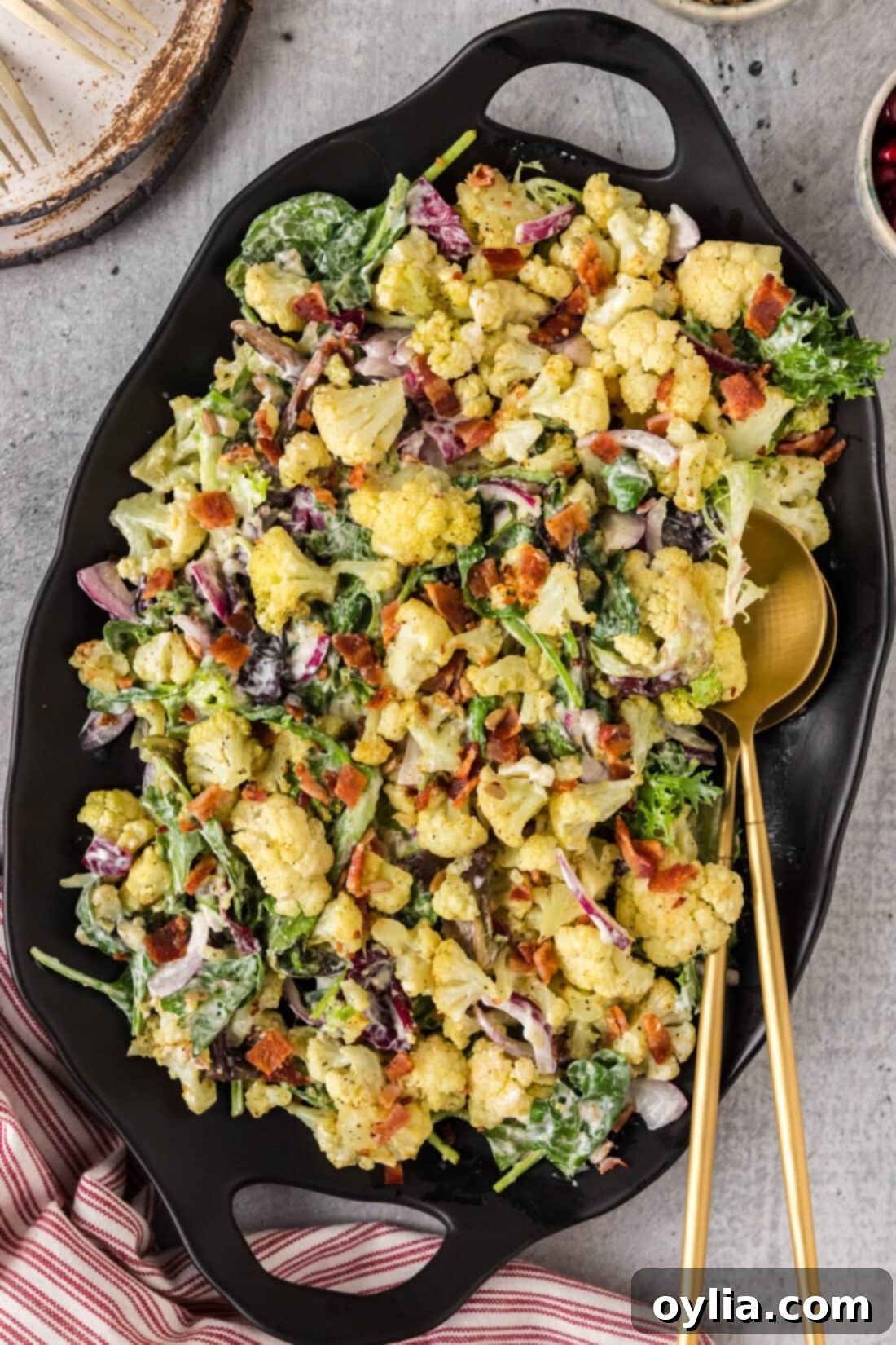 Zesty Cauliflower Salad 2 Cauliflower Salad on a black platter with two serving spoons