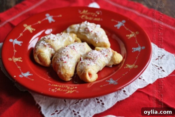 A close up overhead of white chocolate candy cane crescents on a red plate.