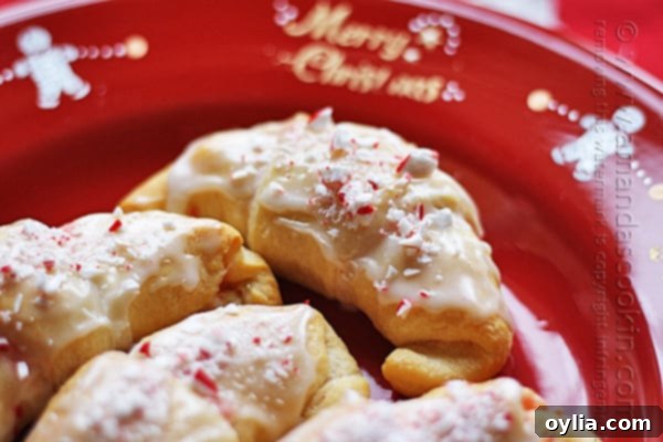 A close up photo of a white chocolate candy cane crescent on a red plate.