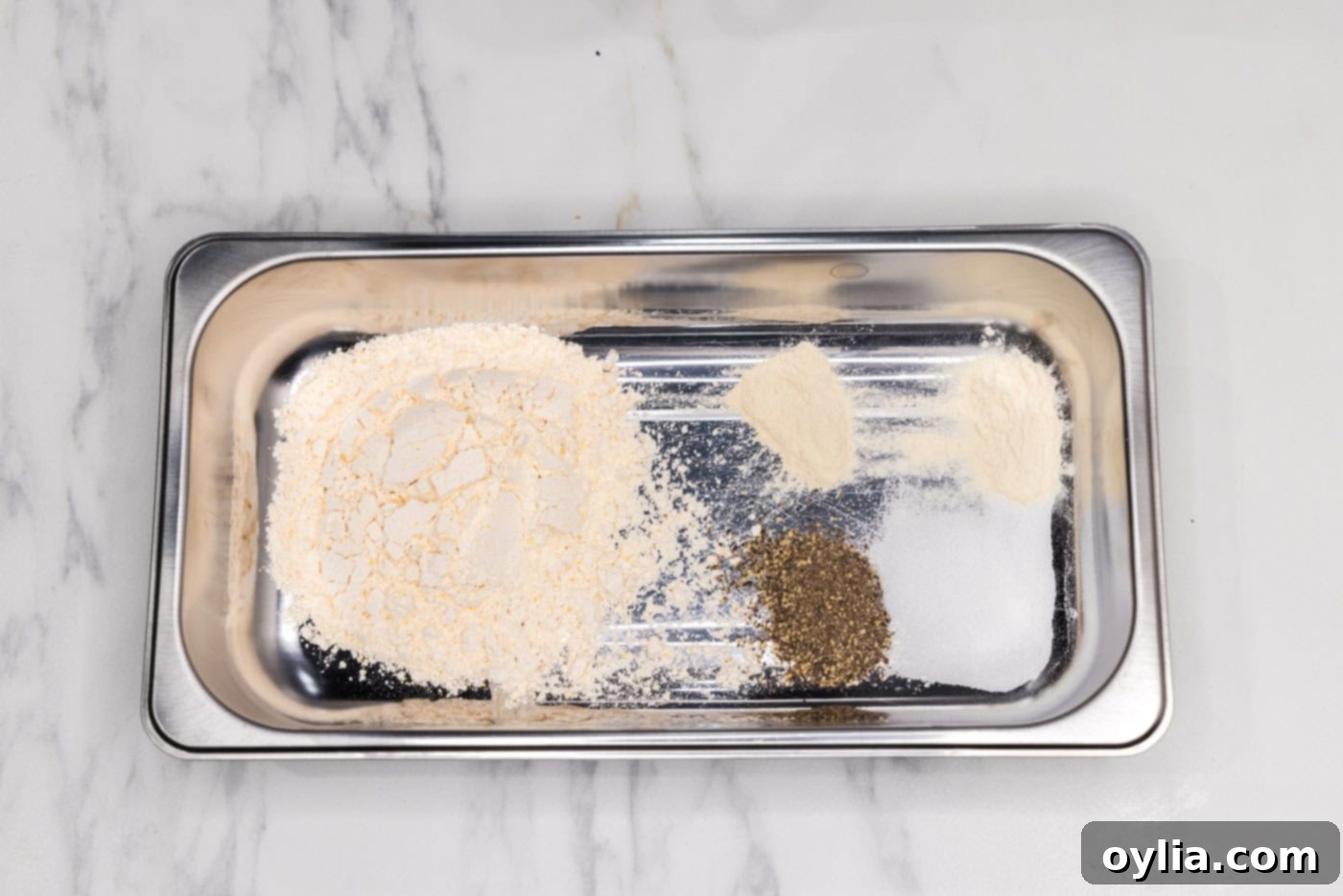 Breading tray with a perfectly mixed blend of flour and seasonings for coating chicken.