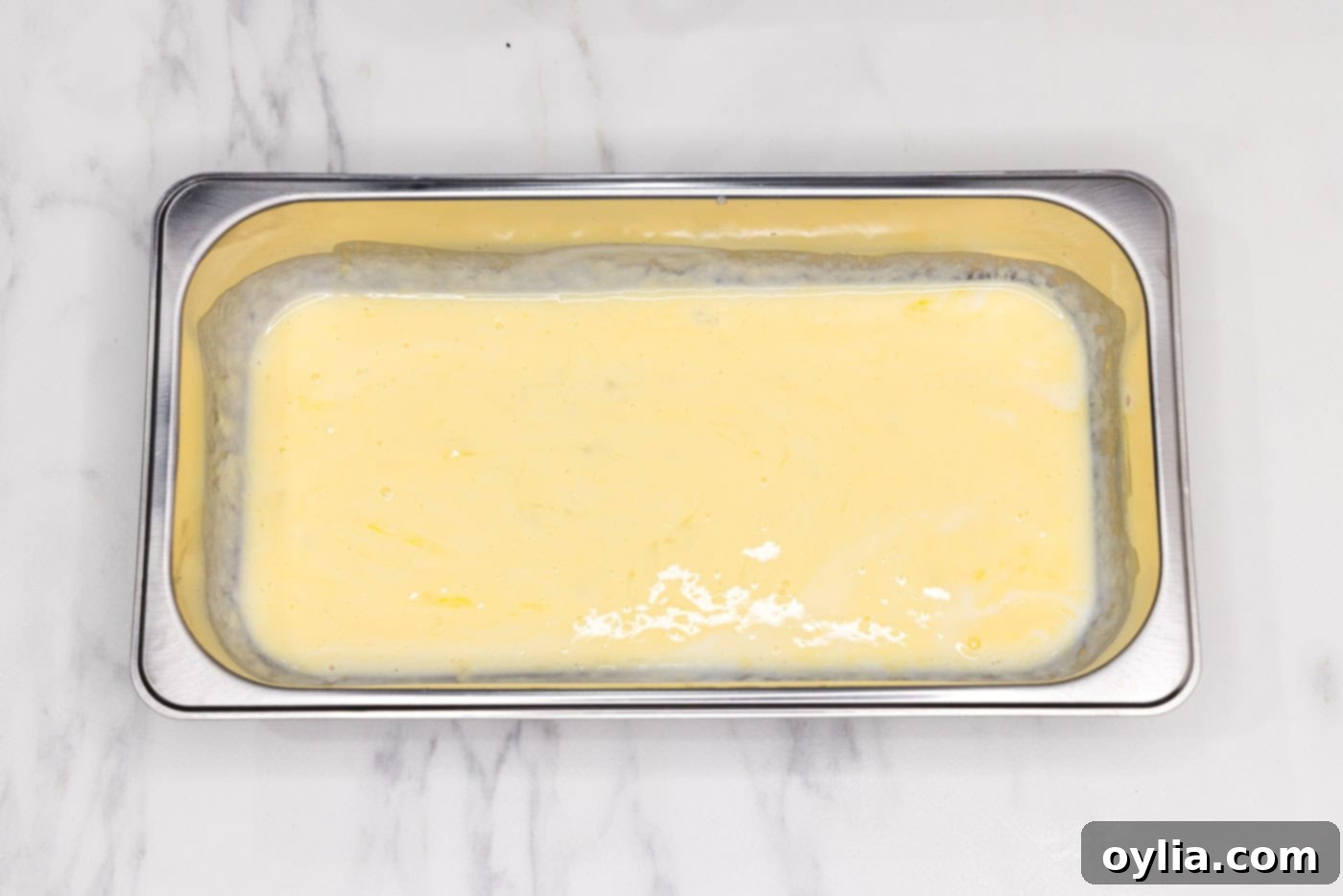 A breading tray filled with a smooth, well-whisked mixture of buttermilk and egg.