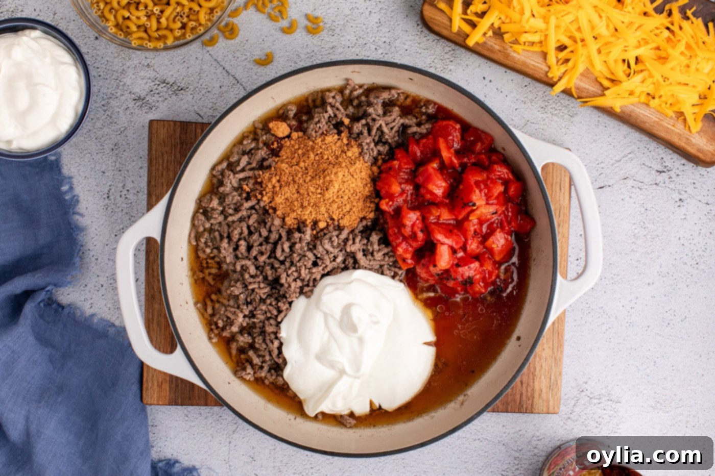 diced tomatoes, taco seasoning, and sour cream added to skillet with ground beef