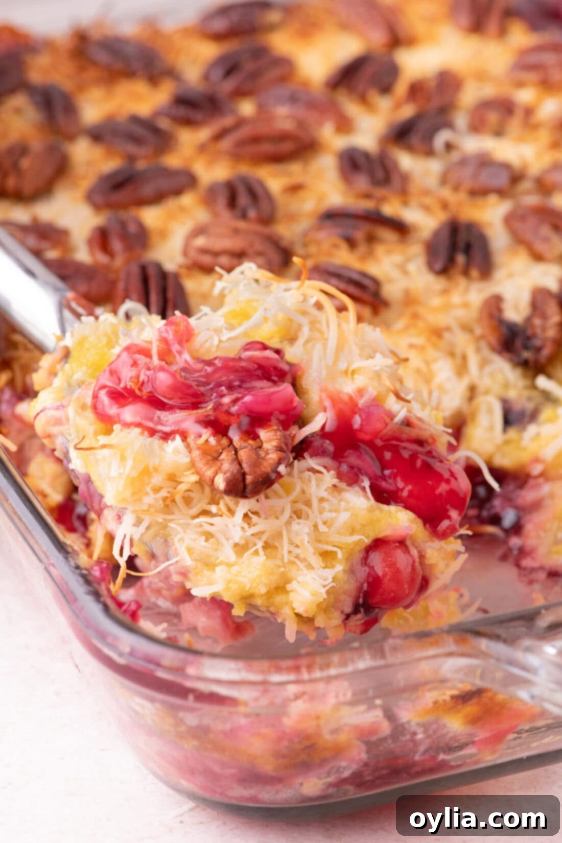 Spoonful of Texas Pie being lifted out of the baking dish, showing the layers of fruit and cake