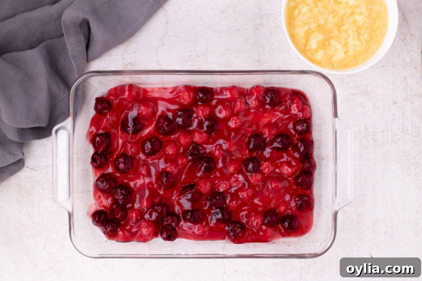 Pitted cherries and cherry pie filling spread evenly in a 9x13 inch baking dish