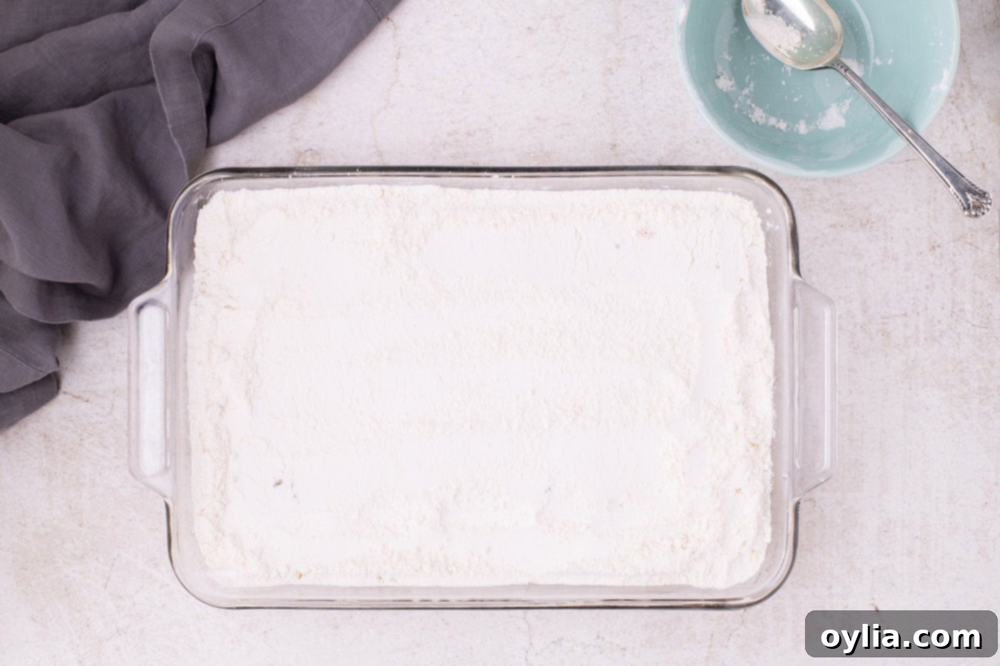 Dry powdered yellow cake mix sprinkled over the pineapple and cherry layers in a baking dish