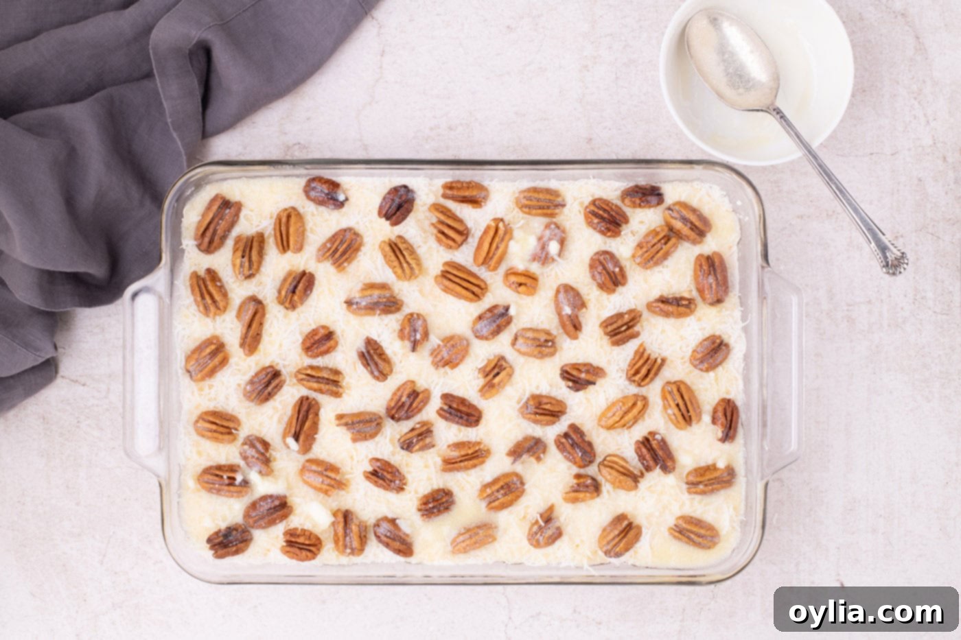 Melted butter being drizzled over the pecan, coconut, and dump cake layers
