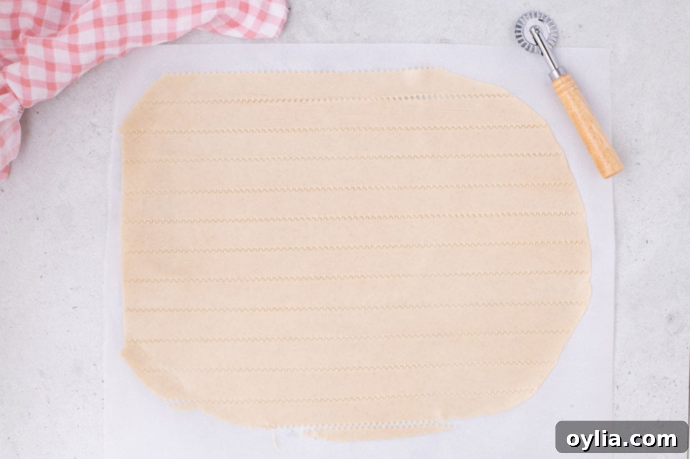 Slicing a pie crust into even strips with a pizza cutter and ruler for the lattice top.