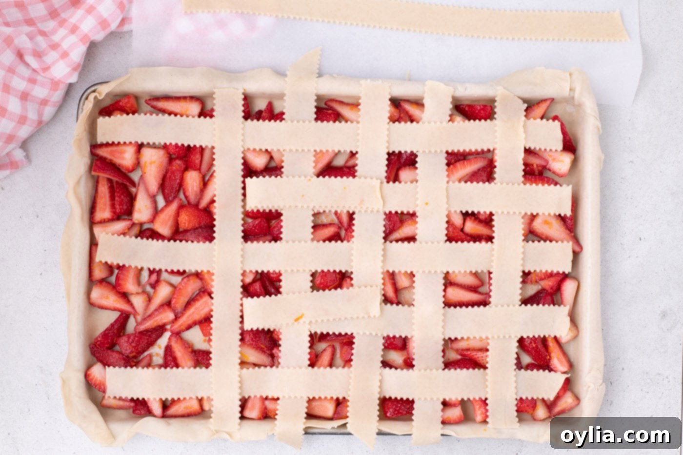 Finished woven lattice top on the strawberry slab pie, showcasing the complete pattern.
