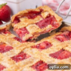 Slice of Strawberry Slab Pie being removed from the pan, showing the golden crust and bubbling filling.