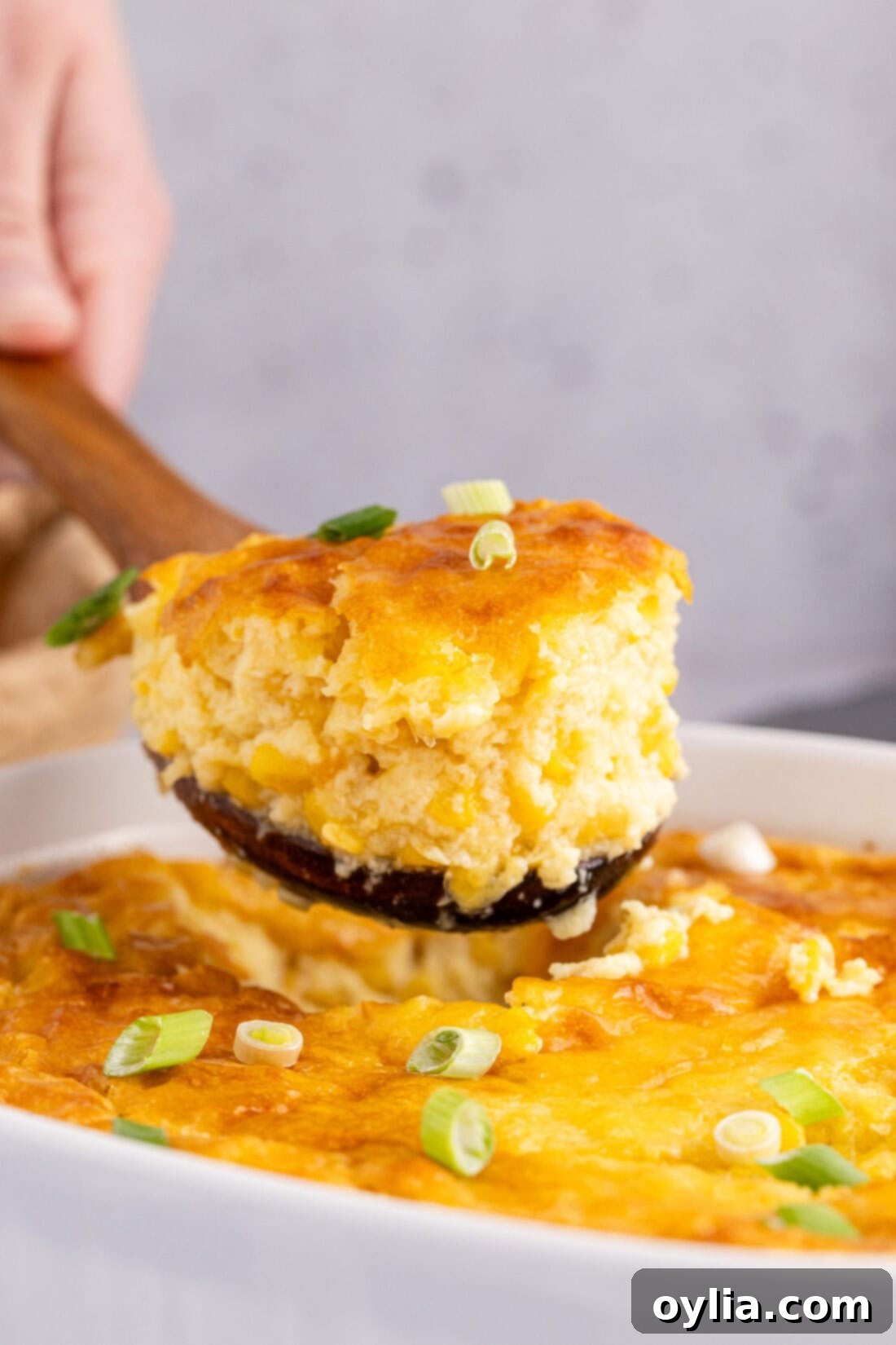 Scoop of Corn Pudding being lifted out of the baking dish