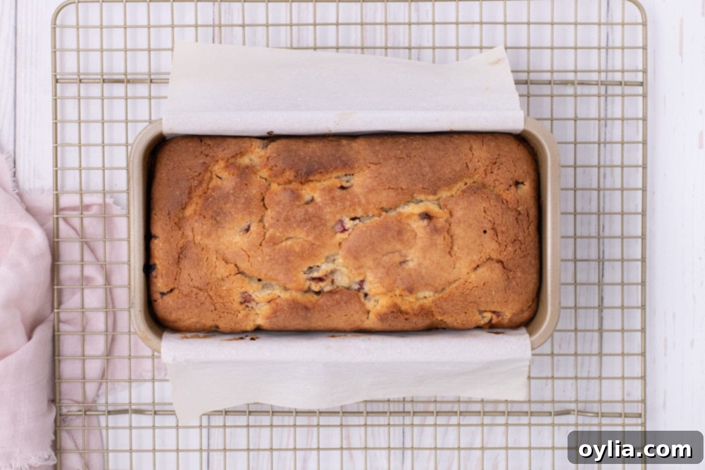 Baked strawberry pound cake, seen from overhead, resting on a cooling rack.