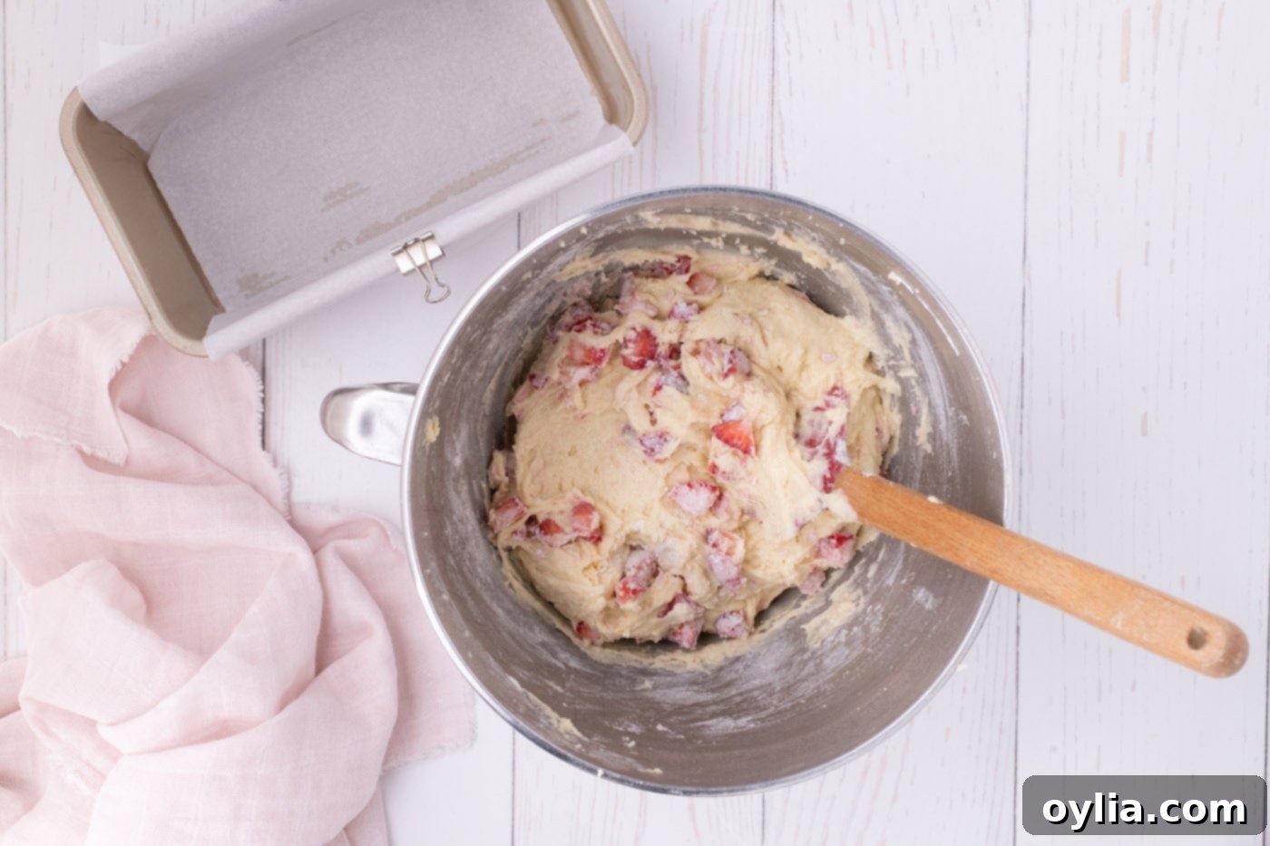 Strawberry pound cake batter in a mixing bowl after folding in strawberries, showing the even distribution.